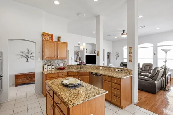 a kitchen with granite countertop kitchen island stainless steel appliances a stove a sink a oven and a refrigerator