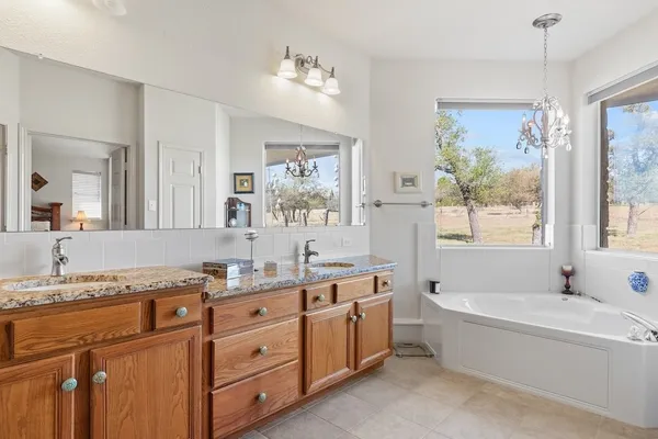 a spacious bathroom with a granite countertop tub sink and mirror