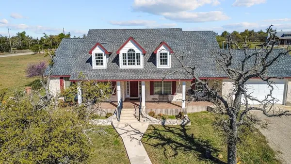 a view of house with yard and seating area