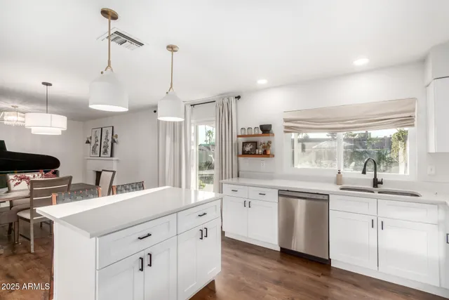 a kitchen with white cabinets and sink