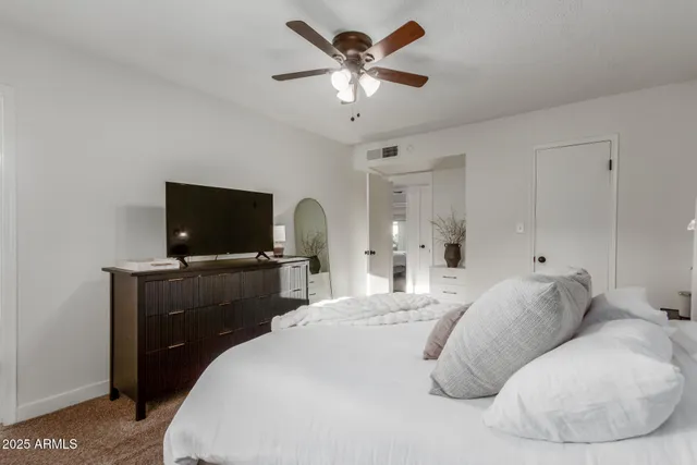 a bedroom with a bed and a flat screen tv