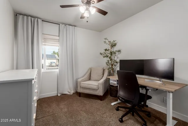a view of a workspace with furniture and a window