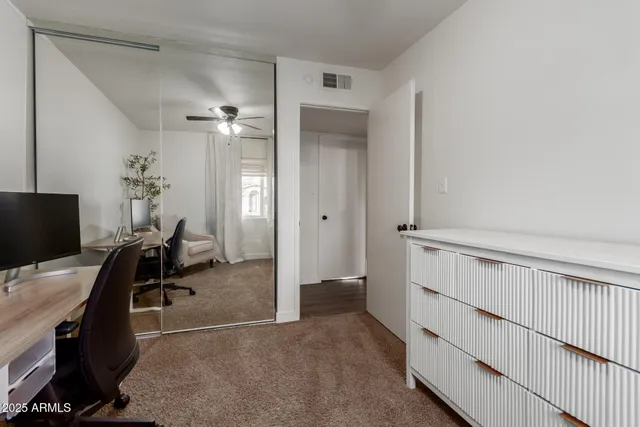 a view of a workspace with furniture and a window