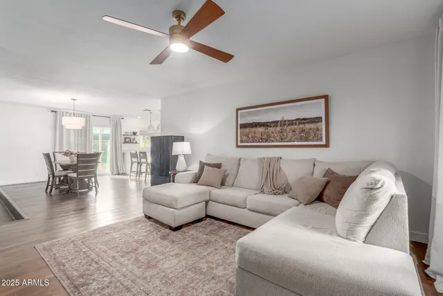 a living room with furniture and a view of kitchen