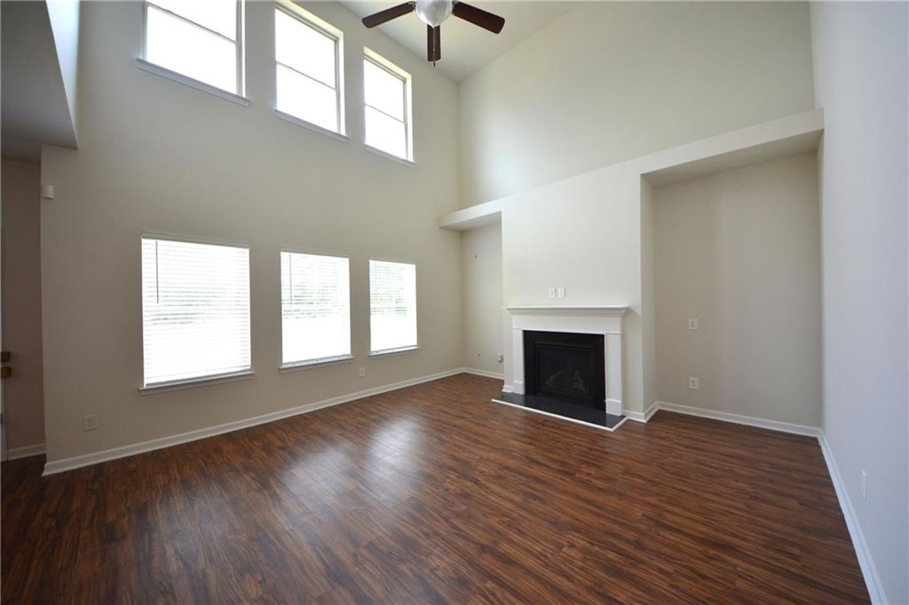 2330 Haliard Way Lithonia, GA 30058 - Photo 16 of 38 an empty room with wooden floor fireplace and windows