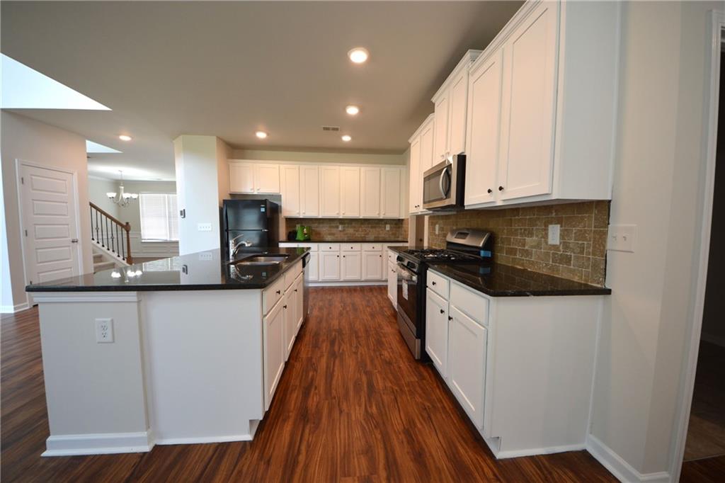 2330 Haliard Way Lithonia, GA 30058 - Photo 21 of 38 a kitchen with granite countertop a sink a counter top space stainless steel appliances and cabinets