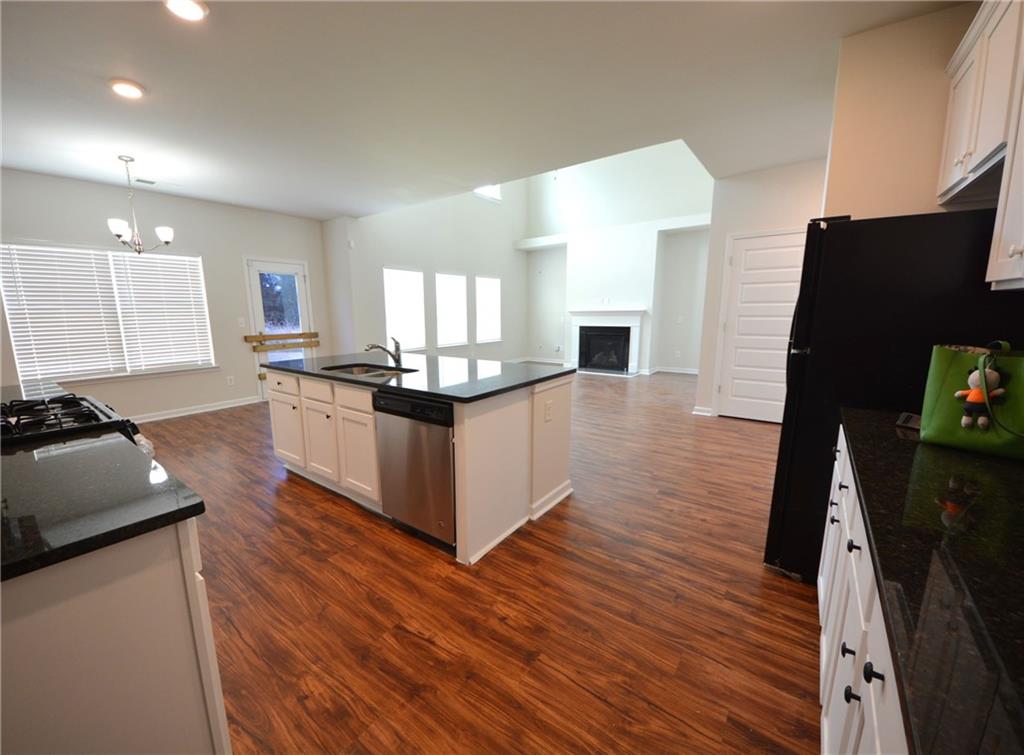 2330 Haliard Way Lithonia, GA 30058 - Photo 23 of 38 a kitchen with stainless steel appliances granite countertop wooden cabinets a refrigerator a sink a stove a microwave and wooden floor