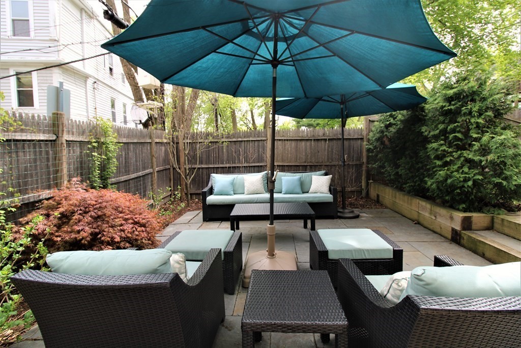39 Hampstead Road, Unit 1 Boston, MA 02130 - Photo 22 of 29 a view of a patio with couches table and chairs under an umbrella