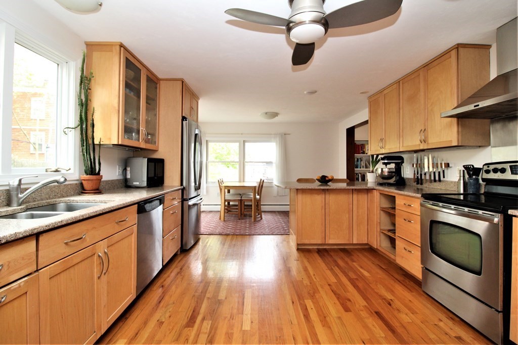 39 Hampstead Road, Unit 1 Boston, MA 02130 - Photo 8 of 29 a kitchen with stainless steel appliances wooden floors stove and white cabinets