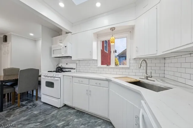 a kitchen with stainless steel appliances granite countertop a sink stove and white cabinets