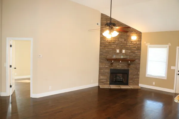 a view of empty room with wooden floor and fireplace