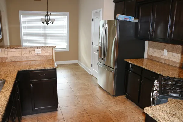 a kitchen with granite countertop a refrigerator and a stove