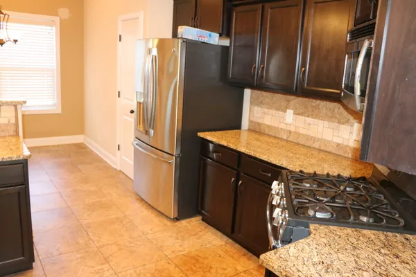 a kitchen with stainless steel appliances granite countertop a refrigerator and a stove