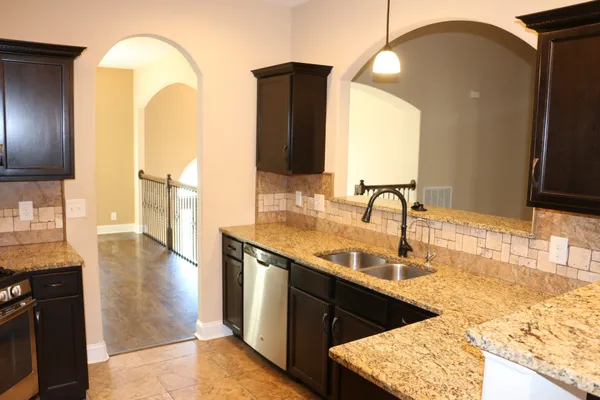 a kitchen with a sink and a wooden floor