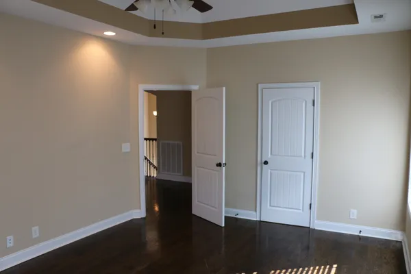 a view of empty room with wooden floor and closet