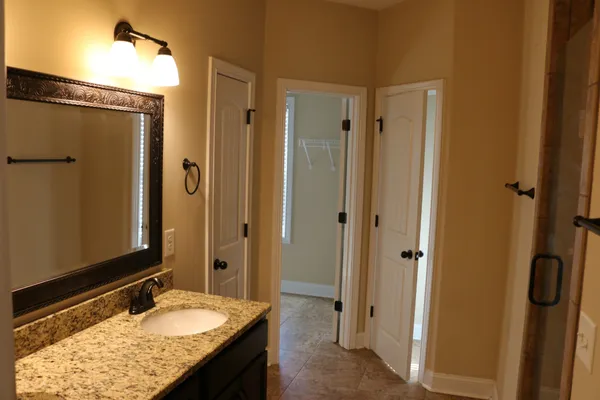 a bathroom with a granite countertop sink shower and a mirror