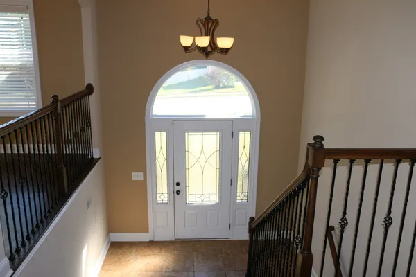 a view of a hallway with wooden floor and stairs
