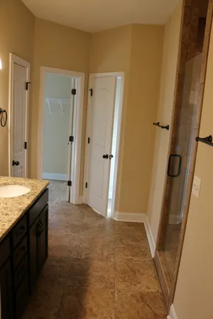a bathroom with a granite countertop sink a mirror and a shower