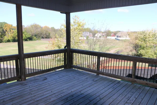 an empty room with wooden floor and a balcony