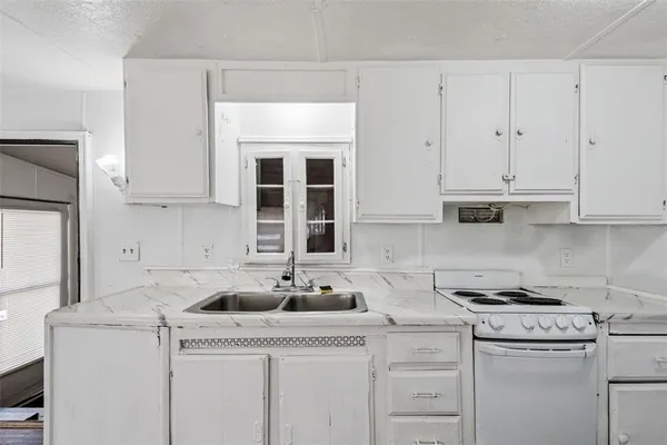 a kitchen with a refrigerator a sink and wooden floor