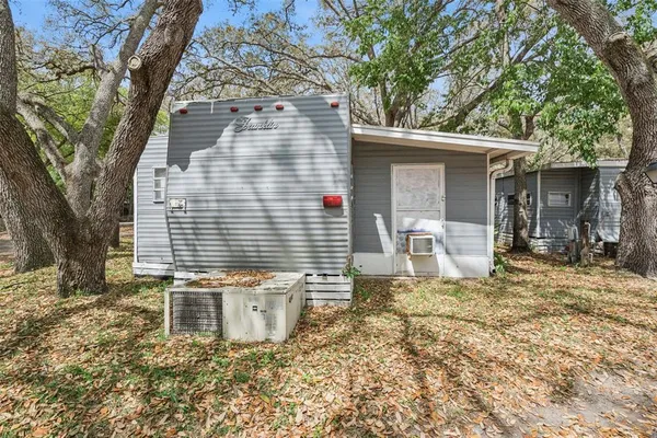 a view of a house with backyard and tree