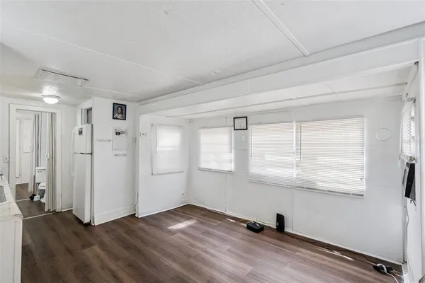 a kitchen with a refrigerator and white cabinets