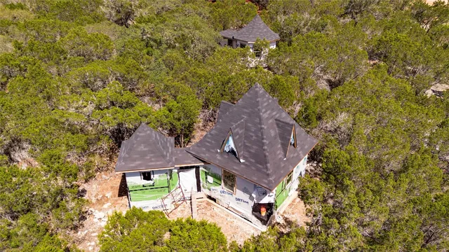 an aerial view of house with yard and trees around