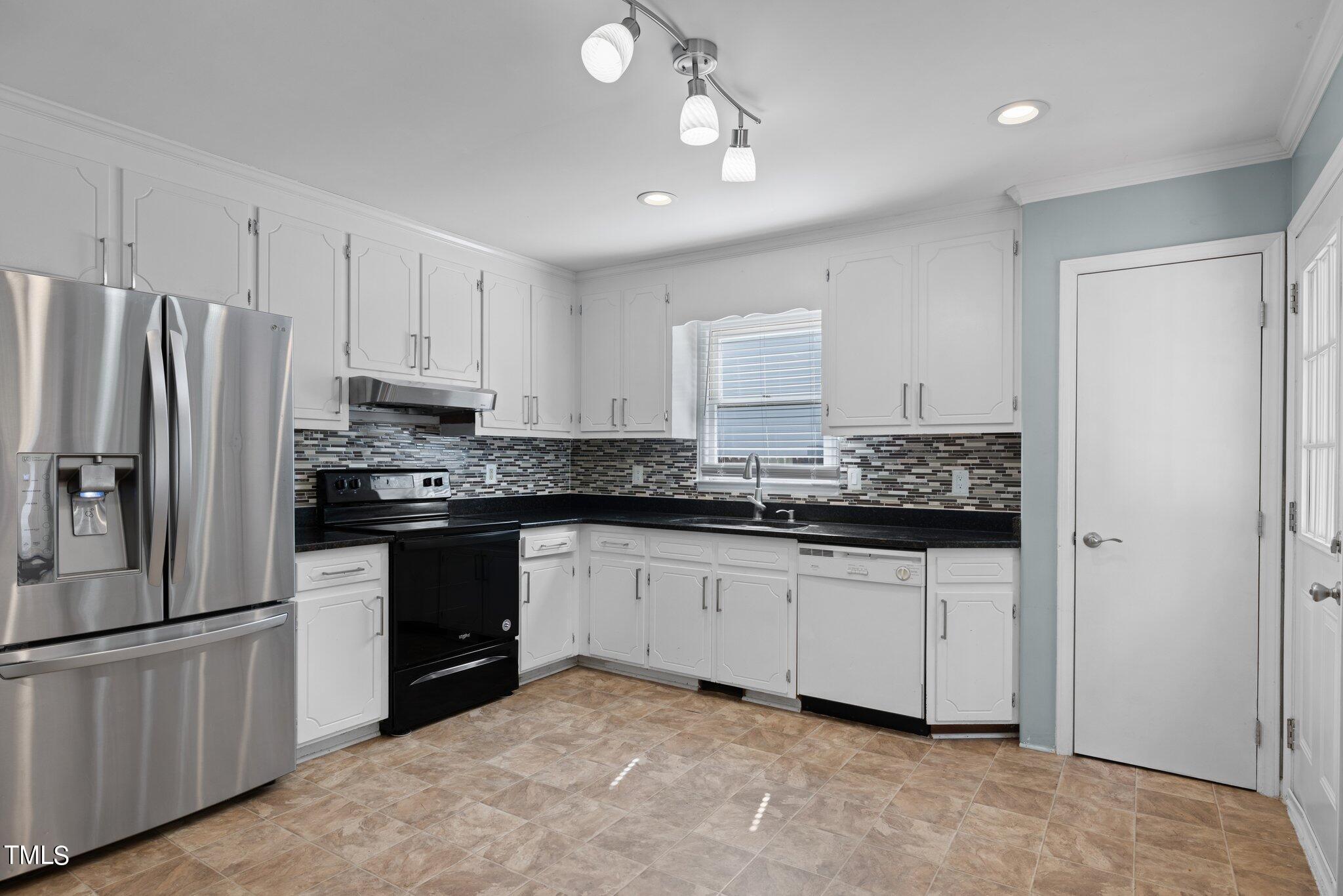 4209 Timberbrook Drive Raleigh, NC 27616 - Photo 11 of 39 a kitchen with granite countertop a refrigerator sink and cabinets