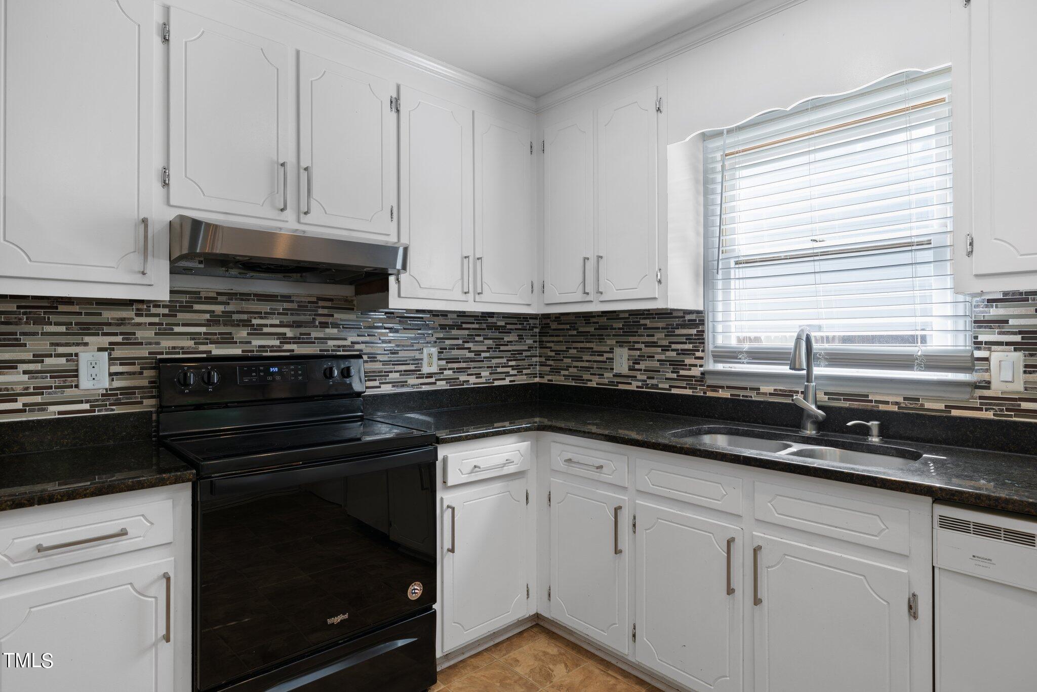 4209 Timberbrook Drive Raleigh, NC 27616 - Photo 12 of 39 a kitchen with granite countertop white cabinets and a stove a sink