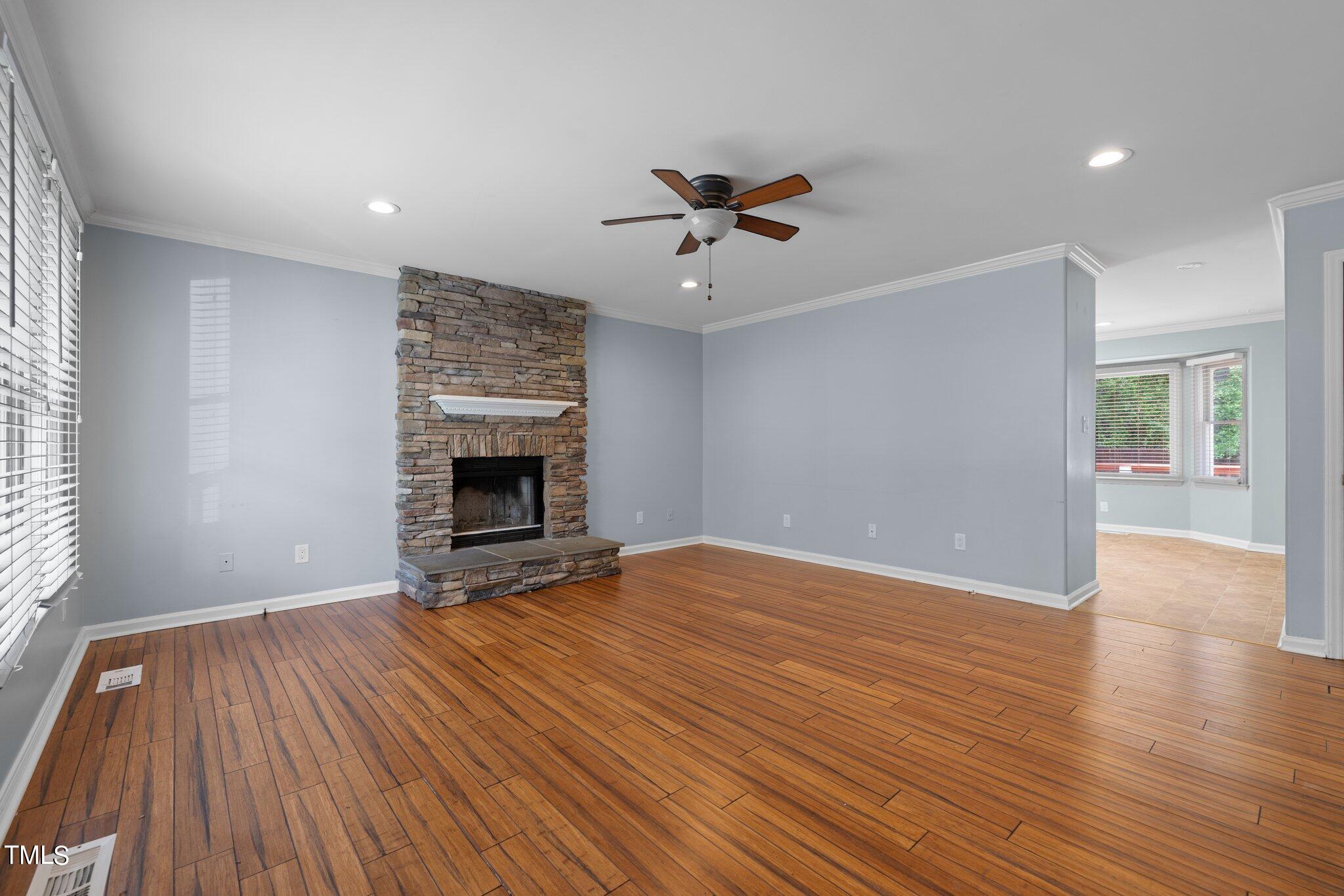 4209 Timberbrook Drive Raleigh, NC 27616 - Photo 6 of 39 an empty room with wooden floor ceiling fan and windows