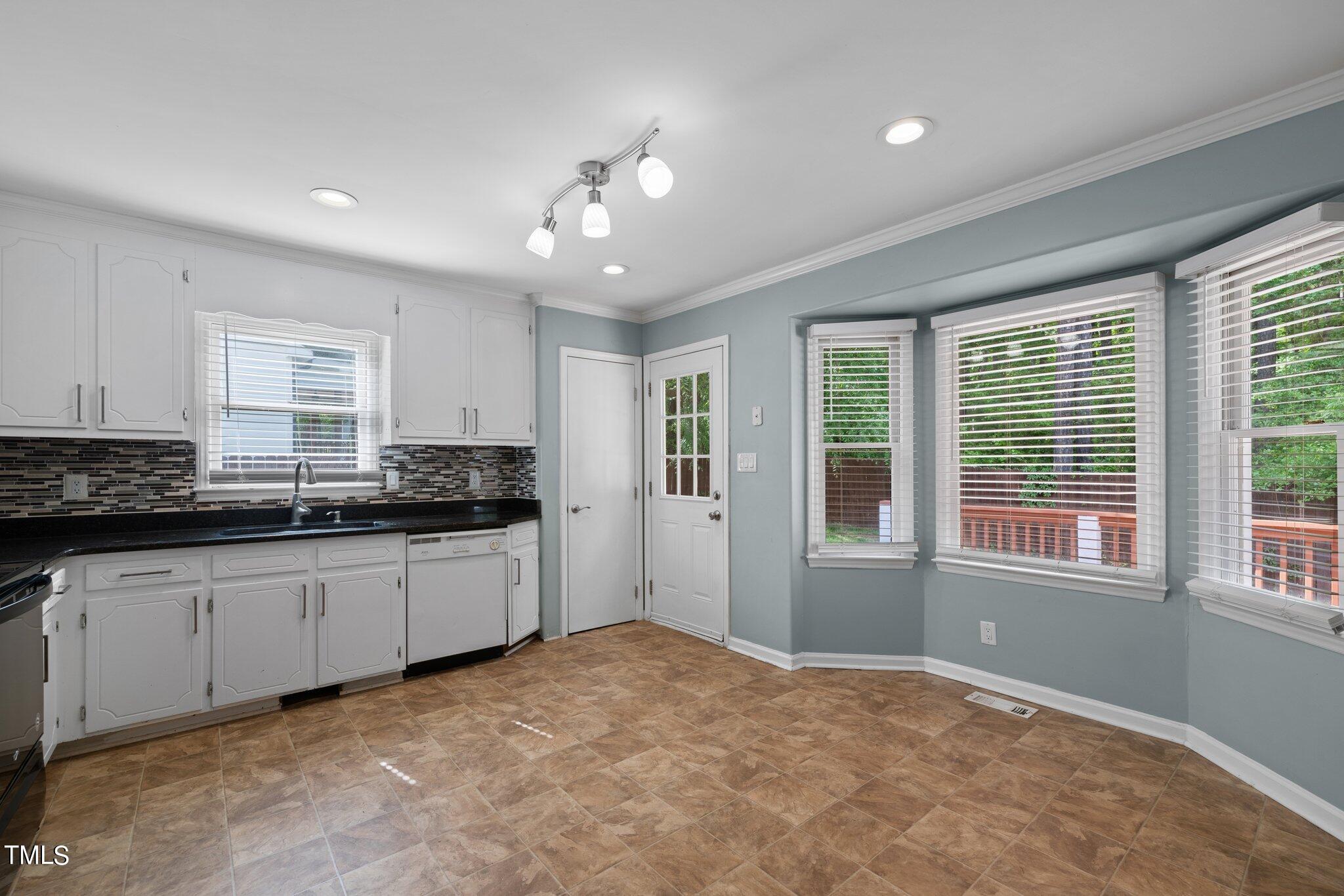 4209 Timberbrook Drive Raleigh, NC 27616 - Photo 10 of 39 a large white kitchen with granite countertop a stove and cabinets