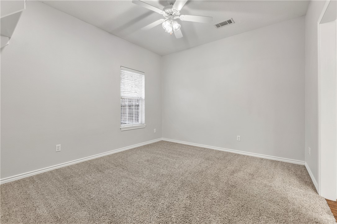 204 Fraternity Row College Station, TX 77845 - Photo 19 of 21 an empty room with a chandelier fan and windows