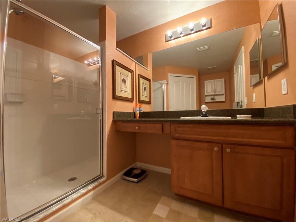 12940 Positano Circle, Unit 204 Naples, FL 34105 - Photo 14 of 39 a bathroom with a sink and a mirror