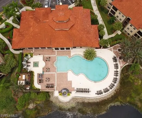 an aerial view of a house with a swimming pool and red umbrella