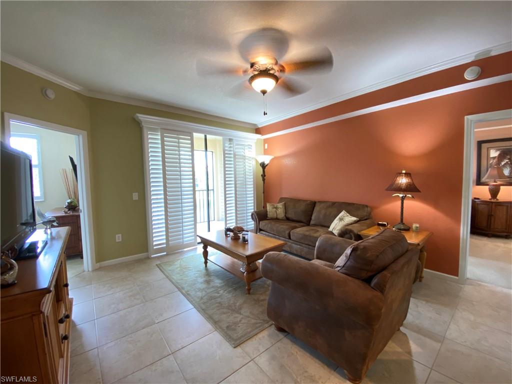 12940 Positano Circle, Unit 204 Naples, FL 34105 - Photo 9 of 39 a living room with furniture and a flat screen tv