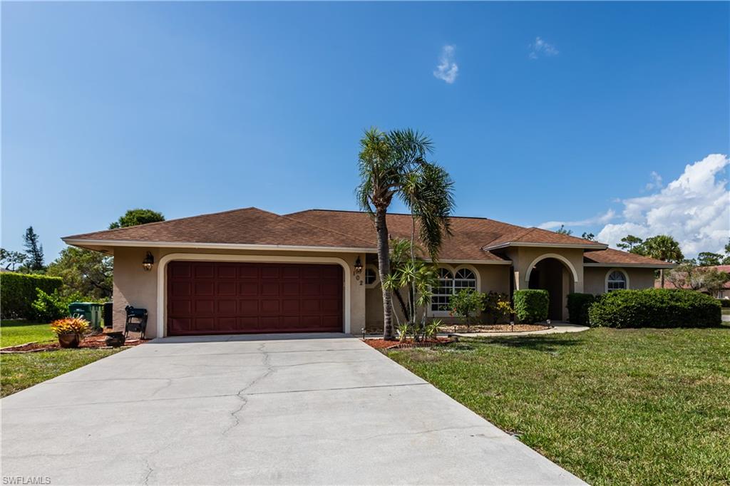 102 Cedar Crest Court Naples, FL 34113 - Photo 1 of 15 a front view of a house with a garden and yard