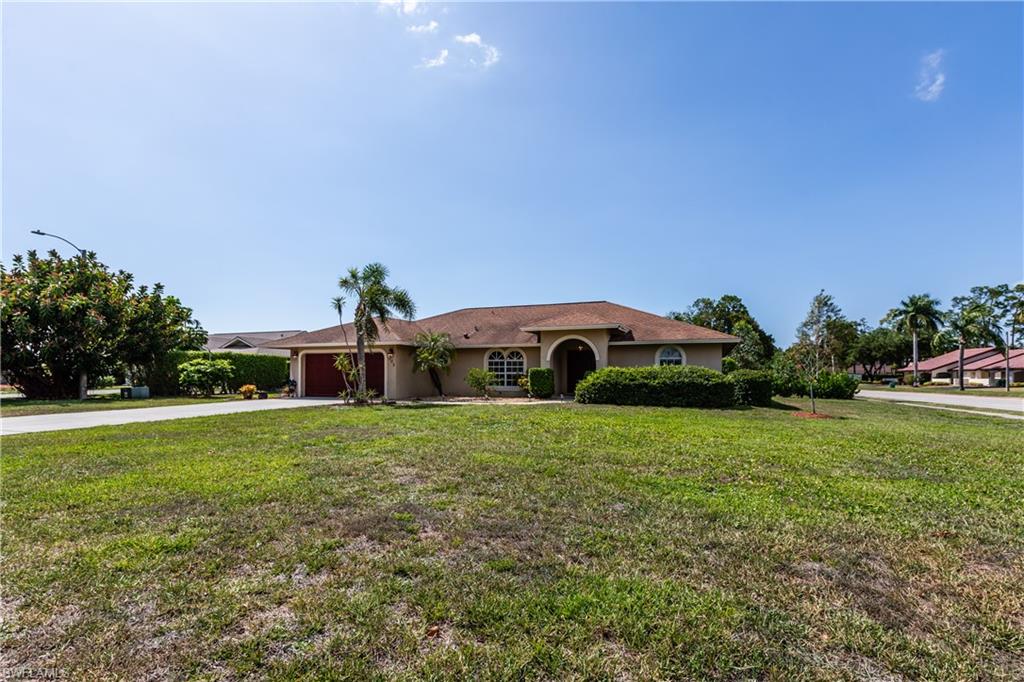 102 Cedar Crest Court Naples, FL 34113 - Photo 15 of 15 a view of a big house with a big yard and large trees