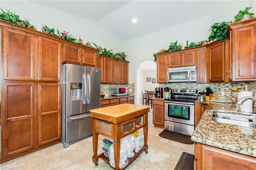 102 Cedar Crest Court Naples, FL 34113 - Photo 3 of 15 a kitchen with stainless steel appliances granite countertop a refrigerator stove and oven