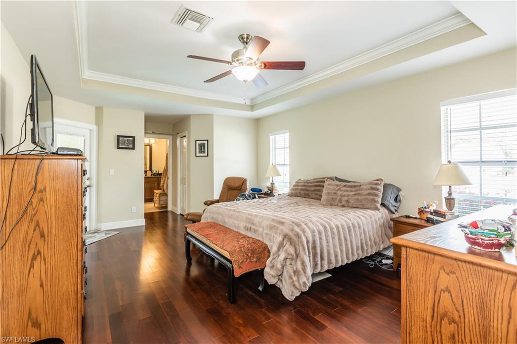 102 Cedar Crest Court Naples, FL 34113 - Photo 5 of 15 a bedroom with a bed and a chandelier