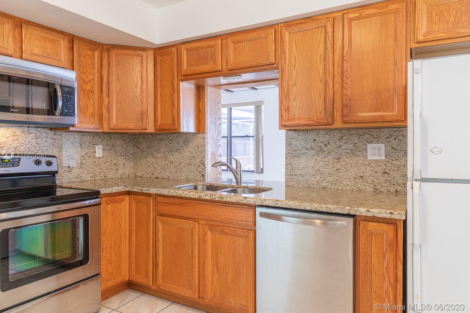 5416 Jefferson Street Hollywood, FL 33021 - Photo 29 of 70 a kitchen with stainless steel appliances granite countertop a sink stove and microwave