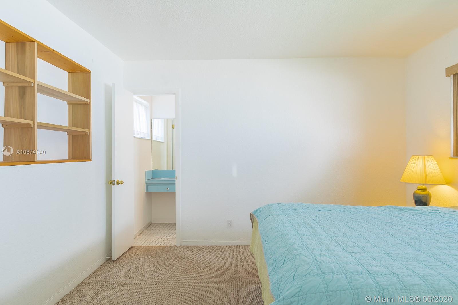 5416 Jefferson Street Hollywood, FL 33021 - Photo 54 of 70 a bedroom with a bed and a lamp
