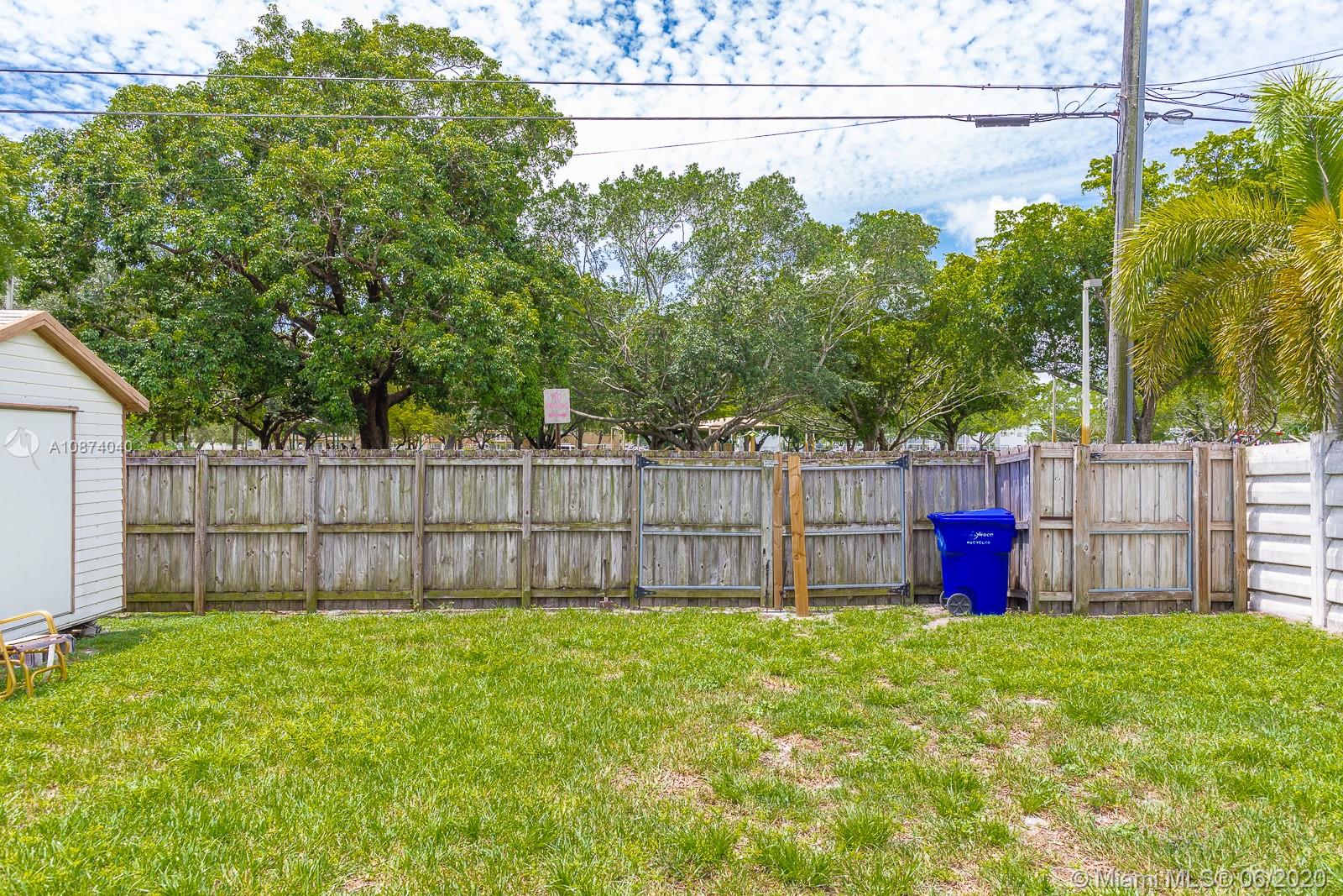 5416 Jefferson Street Hollywood, FL 33021 - Photo 67 of 70 a view of a backyard with large trees and wooden fence