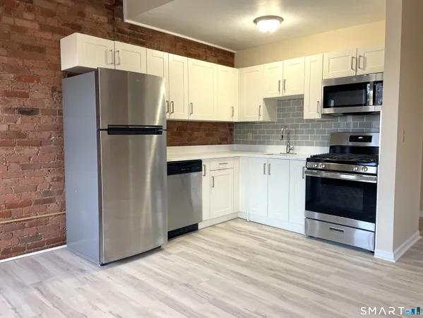 a kitchen with stainless steel appliances a refrigerator stove and microwave