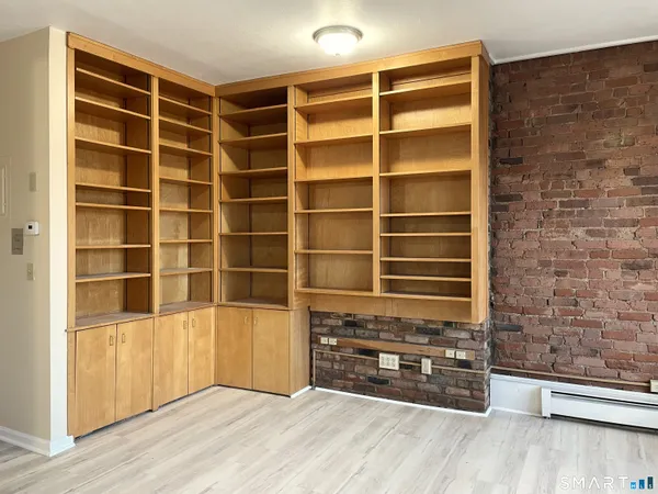 a view of an empty room with a wooden door and a window