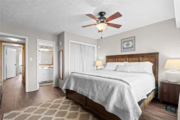 a bedroom with a bed a chandelier and a flat screen tv