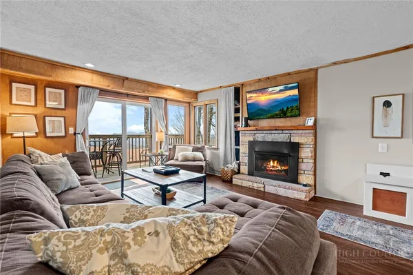 a living room with furniture a large window and a fireplace