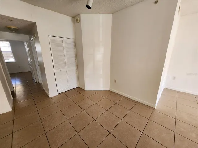 an empty room with wooden floor and mirror in closet