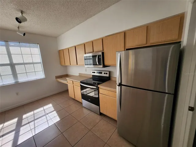 a kitchen with stainless steel appliances a refrigerator sink and microwave