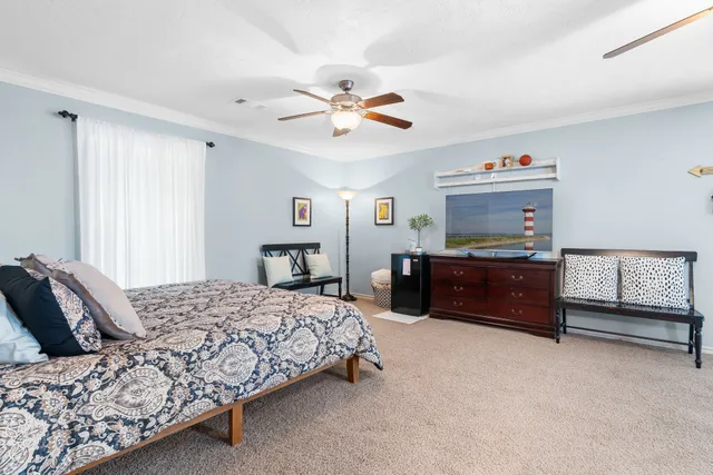 a bedroom with a bed furniture and a ceiling fan