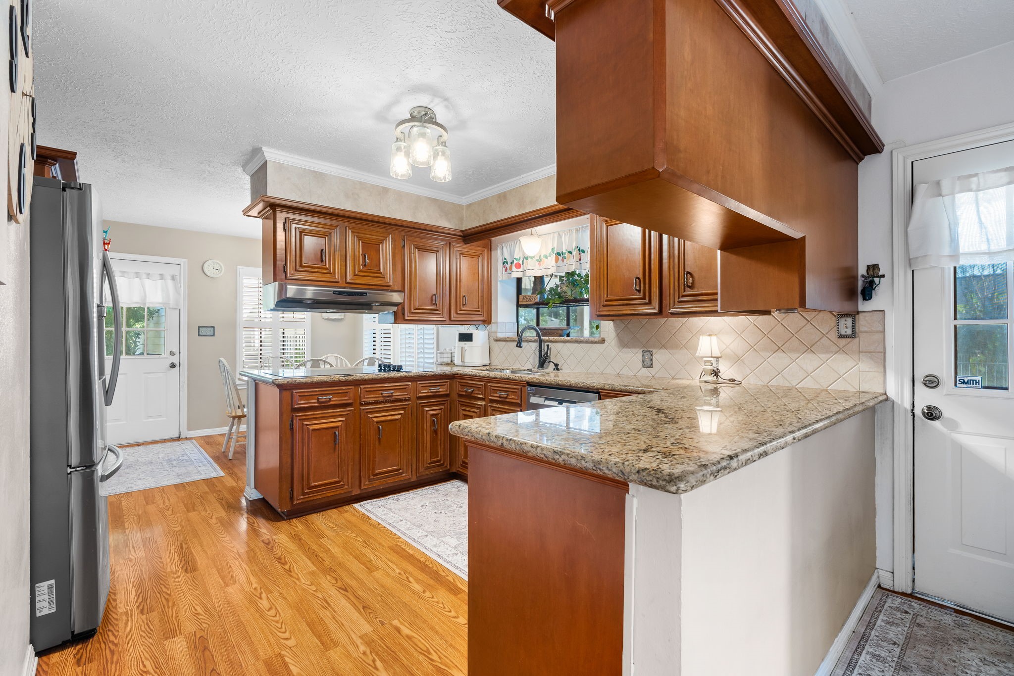6971 Breezy Point Willis, TX 77318 - Photo 5 of 49 a kitchen with stainless steel appliances granite countertop wooden cabinets a sink and dishwasher